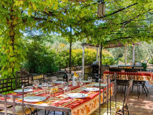 une table avec des assiettes et des verres dessus sous un auvent dans l'établissement Holiday Home Villa Hestia by Interhome, au Thoronet