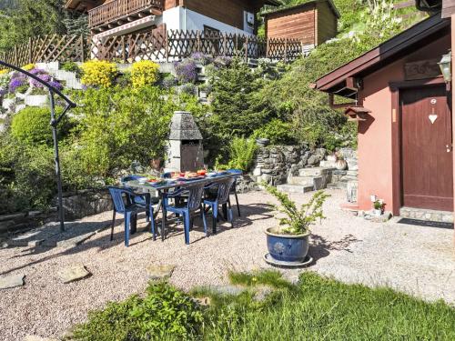 a patio with a table and chairs in a garden at Chalet Le Boletus by Interhome in Saclentse