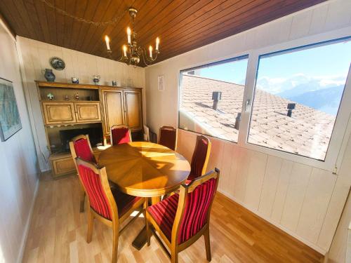 a dining room with a table and chairs and a window at Apartment Lilo-4-Zimmer by Interhome in Beatenberg