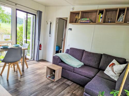 バイルングリースにあるHoliday Home Tiny Haus am Altmühlufer by Interhomeの紫色のソファとテーブルのあるリビングルーム