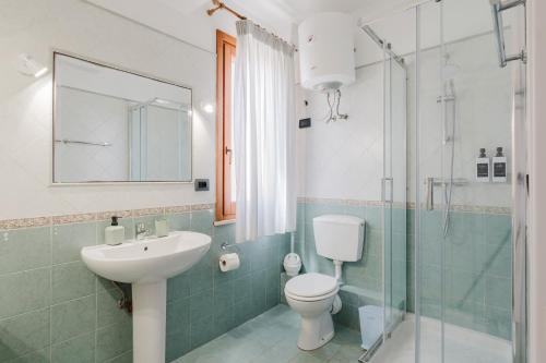 a bathroom with a sink and a toilet and a shower at Kairos San Vito Lo Capo in San Vito lo Capo