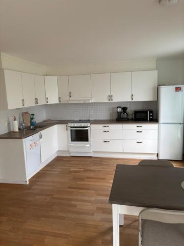 una cucina con armadi bianchi e un tavolo di Kroken3 the apartment a Gravdal