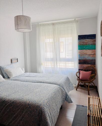 a bedroom with a bed and a chair and a window at VerdeAgua Cantabria con Piscina in Ajo