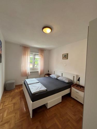 a bedroom with a bed and a window at Apartman Romina in Pula