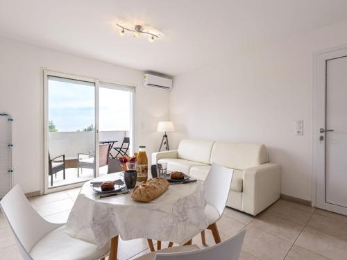 un salon avec une table, des chaises et un canapé dans l'établissement Studio Casa Brigitte by Interhome, à Linguizzetta