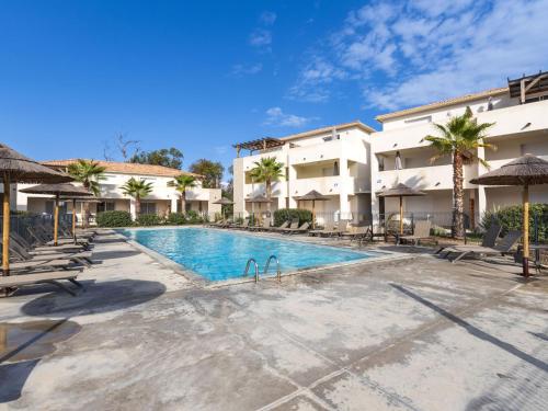 une piscine dans un complexe hôtelier avec chaises et parasols dans l'établissement Studio Casa Brigitte by Interhome, à Linguizzetta