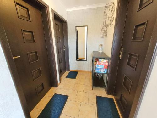 a hallway with two brown doors and blue rugs at Pokoje Goscinne MNICH in Przewłoka