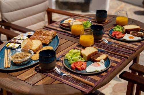 a wooden table topped with plates of breakfast foods at Blue Vine Villa Pool Breakfast in Kamari