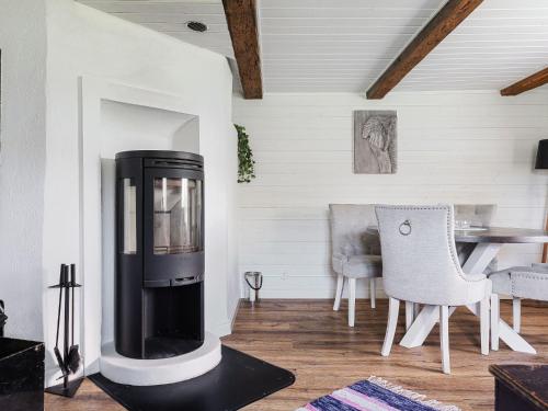 a living room with a fireplace and a table at Holiday Home Strömslund by Interhome in Tävelsås