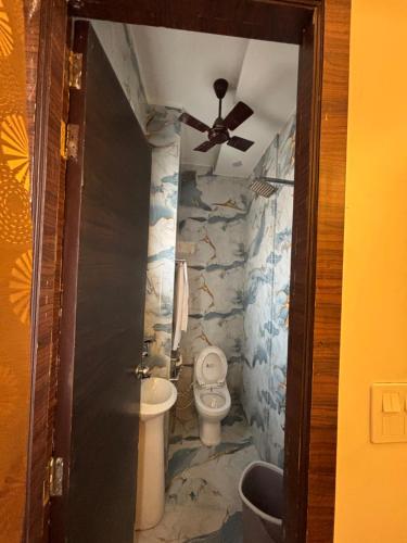 a bathroom with a toilet and a ceiling fan at SEVEN SEVEN HOMESTAy in Amritsar
