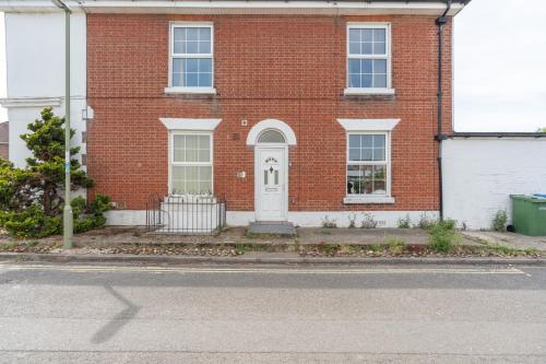 a brick house with a white door on a street at Open Mind Property - 4 Bedroom with 7 Double Beds in Fareham
