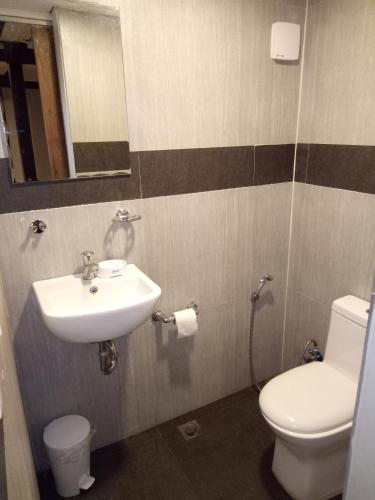 a bathroom with a sink and a toilet and a mirror at El Nido downtown apartment in El Nido