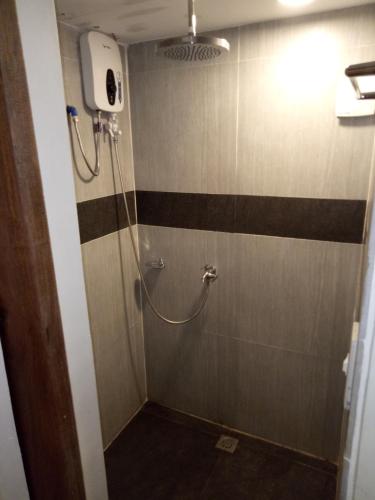 a bathroom with a shower with black and brown stripes at El Nido downtown apartment in El Nido