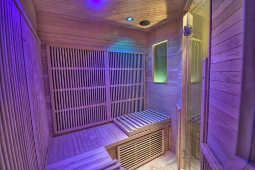 a wooden sauna with purple lights in a room at Au Sauna de Maintenon in Maintenon