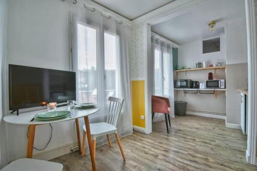 un salon avec une table et une grande fenêtre dans l'établissement Au Sauna de Maintenon, à Maintenon