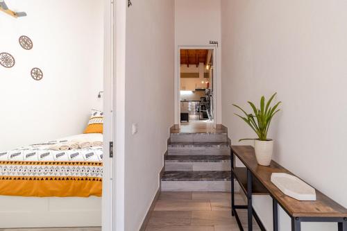 a bedroom with a bed and a table and stairs at Cantinho da Deolinda in Luz