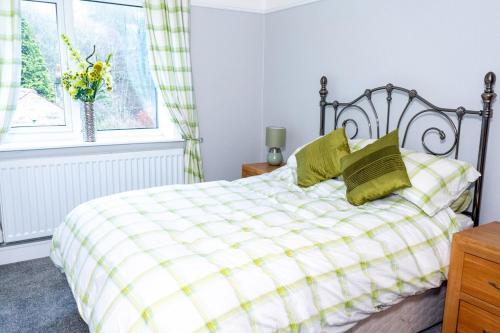 a bedroom with a bed with green pillows and a window at 3 bedroom house in Walsden