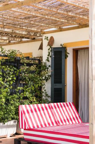 a red and white striped bench in front of a house at Llucatx Menorca in Son Parc