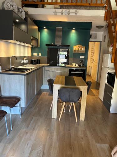 une grande cuisine avec une table et des chaises en bois dans l'établissement Charmante maison 2 ch avec cour, au Grau-du-Roi