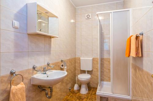 a bathroom with a sink and a toilet and a shower at Apartments Villa Orange in Medulin