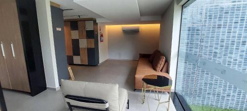 a living room with a couch and a window at Allure Residence - Studios em Boa Viagem por Yolo in Recife