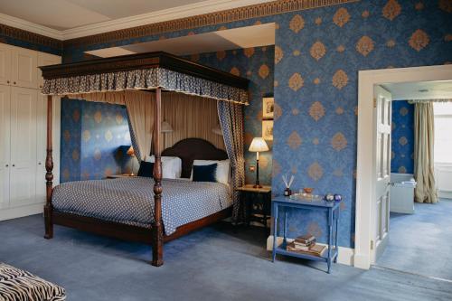 a bedroom with a canopy bed and blue wallpaper at Slane Castle in Slane