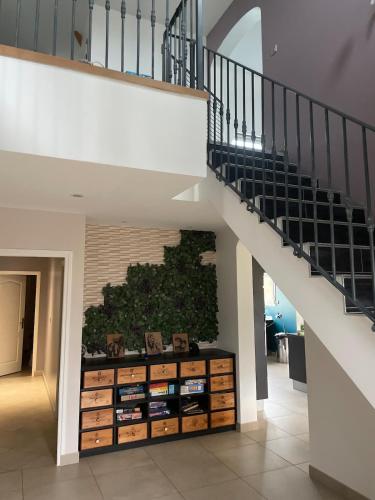 a staircase with a book shelf under a stair case at Maison à louer in Yèvres