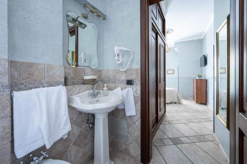 a bathroom with a sink and a mirror and towels at Sunrise Guest House in Maiori
