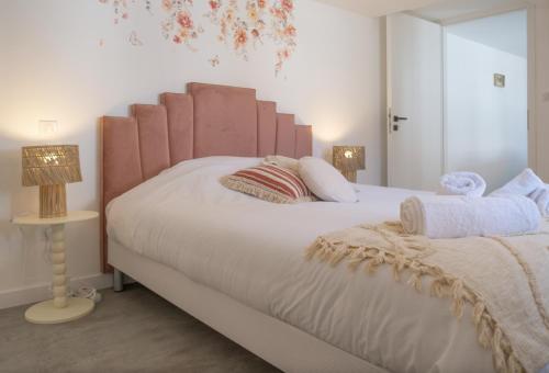 une chambre avec un grand lit blanc avec deux lampes dans l'établissement La Station Paisible - Maison proche Gare, à Brumath