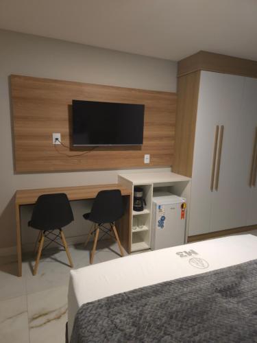 カマサリにあるQuarto Casal ou Duplo M3 Hotelのベッドルーム1室(ベッド1台、椅子2脚、テレビ付)