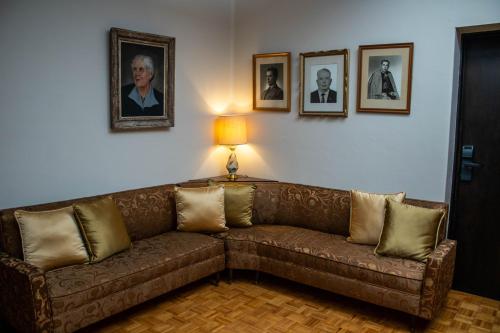 a living room with a couch and portraits on the wall at Mansion de los Abuelos in Atlacomulco de Fabela