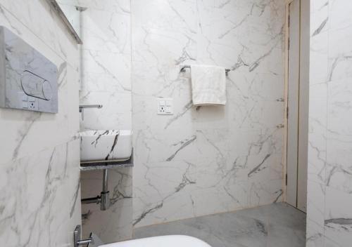 a bathroom with white marble walls and a sink at Comfort N Stay INN Suites in Gurgaon