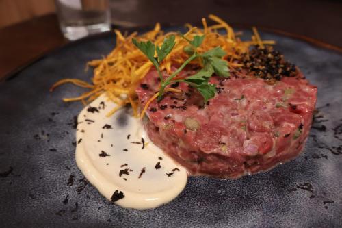 a piece of meat on a plate with sauce and cheese at Pampa Lodge, Quincho & Caballos in Torres del Paine