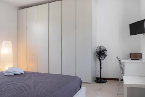 a bedroom with a bed and a desk with a fan at Residenza La Fonte in Laveno-Mombello
