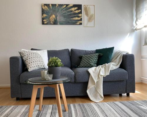 a living room with a blue couch and a table at Ferienwohnung Lee in Bad Neuenahr-Ahrweiler