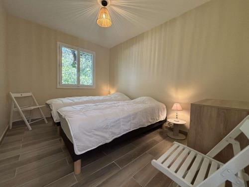 ein Schlafzimmer mit einem Bett, einer Lampe und einem Stuhl in der Unterkunft Maison 6 pièces Oléron 10 couchages- SAINT GEORGES D'OLERON SGO000-065 in Chaucre