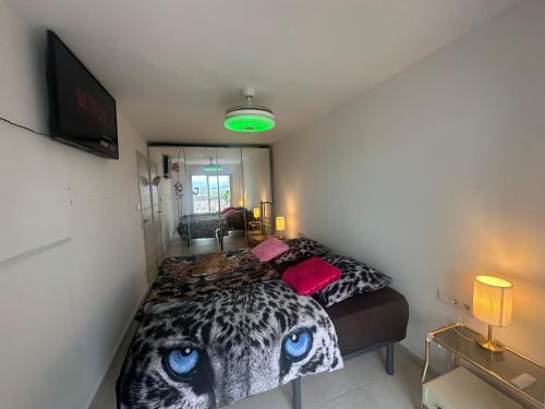 a bedroom with a large bed with blue eyes at Manhattan apartment in Empuriabrava