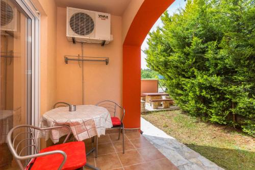 a patio with a table and a air conditioner at Apartments Villa Orange in Medulin