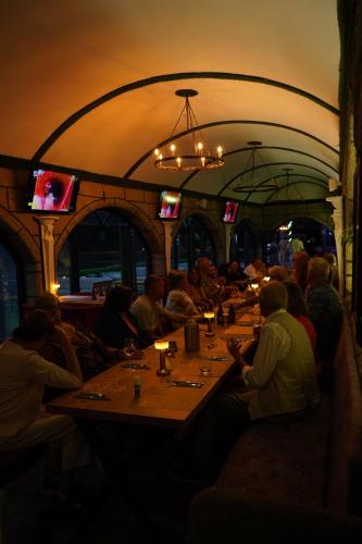 a group of people sitting at tables in a restaurant at BELKA GOLF RESİDENCE Luxury Apt Poolside Belek in Belek