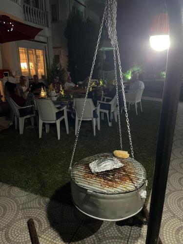 a swing in a yard with people sitting at a restaurant at BELKA GOLF RESİDENCE Luxury Apt Poolside Belek in Belek