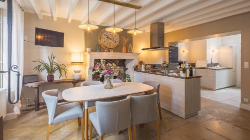 une cuisine et une salle à manger avec une table et des chaises dans l'établissement Villa des Lilas - Champagne & SPA, à Buxeuil