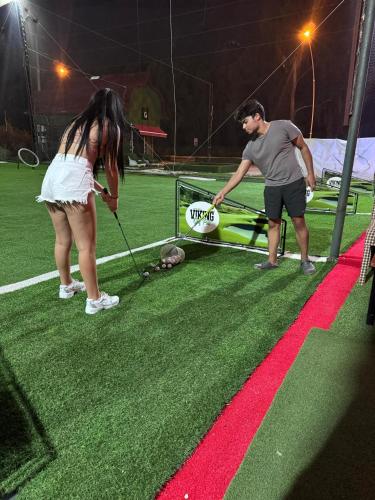 a man and a woman playing with a dog with a frisbee at BELKA GOLF RESİDENCE Luxury Apt Poolside Belek in Belek