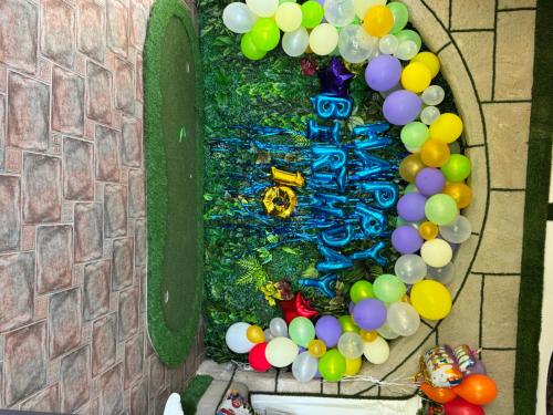 a wall with a bunch of balloons and a table at BELKA GOLF RESİDENCE Luxury Apt Poolside Belek in Belek