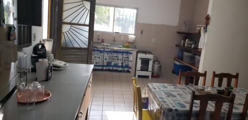 a kitchen with a counter and a table in it at Sítio Chã do Cajá in Sao Benedito do Sul