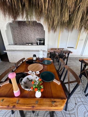 Una mesa de madera en una habitación con mesas y sillas. en Belka Golf Residence POOLSİDE DELUXE, en Belek