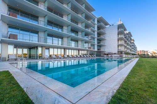 a swimming pool in front of a building at Cond Bayline - Corvina - SPA - POOL - GYM - BEACH - BY BEDZY in Armação de Pêra