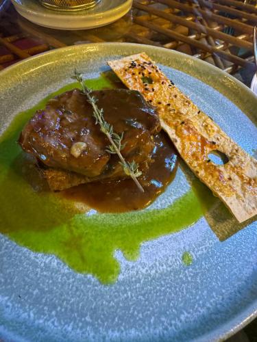 a plate of food with meat and sauce on it at BELKA GOLF RESİDENCE Deluxe apt Poolside BELEK in Belek