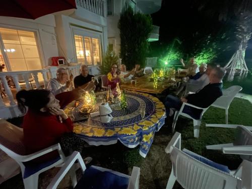 a group of people sitting around a table with candles at BELKA GOLF RESİDENCE Deluxe apt Poolside BELEK in Belek