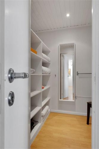 a room with a closet with a mirror and a door at Trevligt hus & Sjöbod i mysiga Mollösund Tången in Mollösund