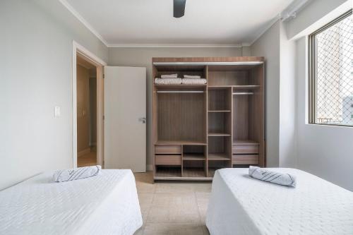 a bedroom with two beds and a closet at Ruth de Sá 3 Dorm Quadra Mar by Achei Camboriú in Balneário Camboriú